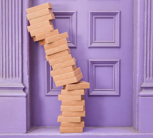 pile of brown boxes beside purple wooden wall